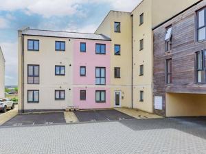 an empty parking lot in front of two buildings at Modern 2-Bedroom Apartment in Bristol