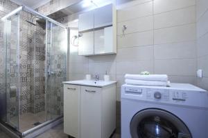 a bathroom with a washing machine and a shower at Neapolis Apartment in Lefkada