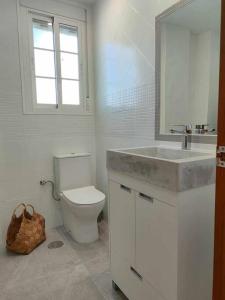 uma casa de banho com um WC, um lavatório e um espelho. em Casa Mirador del Puente em Arcos de la Frontera