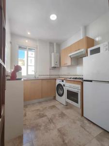 uma cozinha com um frigorífico branco e uma máquina de lavar louça em Casa Mirador del Puente em Arcos de la Frontera