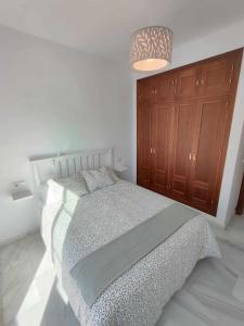 a bedroom with a bed and a wooden cabinet at Casa Mirador del Puente in Arcos de la Frontera