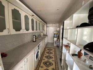 een keuken met witte kasten en een wasmachine bij Kuzey’s home in Karataş