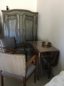 Habitación con mesa, sillas y cómoda. en Brisa en San Antonio de Areco