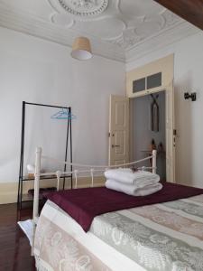 - une chambre avec un lit et des serviettes dans l'établissement Ninho do Corvo, à Torre de Moncorvo
