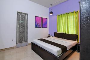 Un dormitorio con una cama y una cortina verde. en Hotel O MOHAPATRA GUEST HOUSE, en Khandagiri