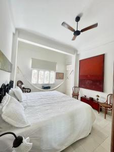 a bedroom with a large white bed and a ceiling fan at Bello apartamento corazón de Cartagena colonial in Cartagena de Indias