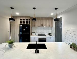 a kitchen with white cabinets and black appliances at 17 Cooyou Close in Exmouth