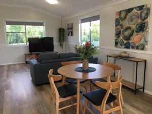 a living room with a couch and a table and chairs at Longreach Private Apartments in Longreach