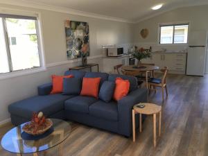 a living room with a blue couch and a kitchen at Longreach Private Apartments in Longreach