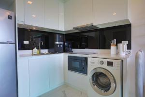 a white kitchen with a washing machine in it at Pratamnak Pattaya Luxury Condo, Golf, Ocean View in Pattaya South