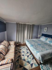 sypialnia z 2 łóżkami i kanapą w obiekcie Casa 3 dormitorios w mieście Ancud