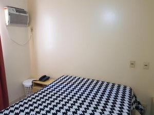 a bedroom with a bed with a black and white checkered blanket at Eldorado Thermas Park RM Hospedagem in Caldas Novas +41 photos
