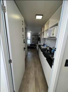 a hallway of a kitchen with a long counter top at Flat com piscina a 200m da praia in Cabedelo
