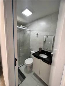 a bathroom with a toilet and a shower and a sink at Flat com piscina a 200m da praia in Cabedelo