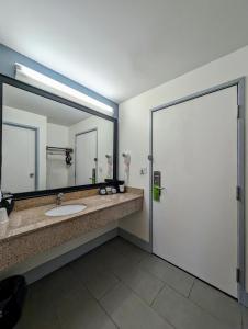 a bathroom with a sink and a large mirror at La Quinta Inn by Wyndham Chicago Willowbrook in Willowbrook