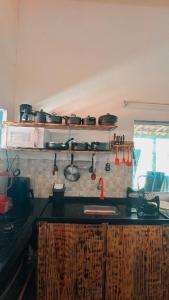 uma cozinha com um balcão com panelas e frigideiras em Hostel Caraivando em Caraíva