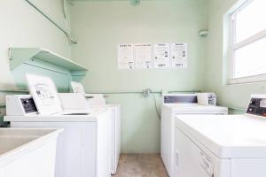 uma lavandaria com máquinas de lavar e secar roupa brancas em Balcony Chic Apt, w/2 Queenbeds, on Ocean Dr Beach em Miami Beach