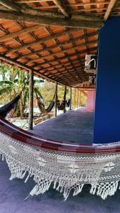 a hammock on a porch of a house at Hostel Caraivando in Caraíva