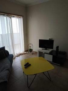 een woonkamer met een bank en een gele salontafel bij Edifice Ibérico in Albufeira