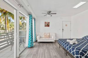 um quarto com uma cama, uma cadeira e uma janela em Balcony Chic Apt, w/2 Queenbeds, on Ocean Dr Beach em Miami Beach