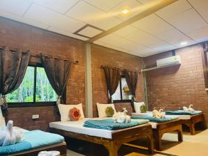 een kamer met drie bedden met knuffels erop bij Khaosok Monkeys & River Camps in Khao Sok