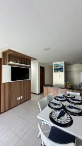 a kitchen with a table with plates on it at Apartamento Doce Lar Resort Treebies Subauma in Subaúma