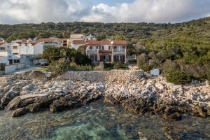 an aerial view of a house next to a body of water at Apartments by the sea Milna, Vis - 8946 in Rukavac