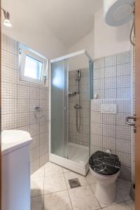 een badkamer met een douche en een toilet bij Apartments by the sea Milna, Vis - 8946 in Rukavac