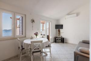 biała jadalnia ze stołem i dwoma oknami w obiekcie Apartments by the sea Milna, Vis - 8946 w mieście Rukavac