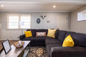 ein Wohnzimmer mit einem schwarzen Sofa und gelben Kissen in der Unterkunft The Country Escape in Canyon