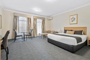 谢珀顿Sherbourne Terrace Hotel的一间带床、桌椅的酒店房间 更多23张照片