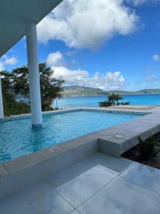 a swimming pool with a view of the ocean at Villa Sunrise RD in Las Galeras