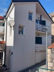 a white house with a balcony on the side at Studio Gradac 15642b in Gradac