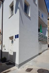 a white building with a door and a balcony at Studio Gradac 15642b in Gradac
