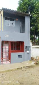 a house with a red door and a gate at Mini Casa em Arraial d'Ajuda in Porto Seguro