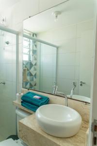 a bathroom with a white sink and a mirror at Apartamento privativo Pindamonhangaba-SP in Pindamonhangaba