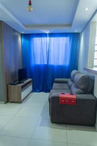 a living room with a couch and a television at Apartamento privativo Pindamonhangaba-SP in Pindamonhangaba