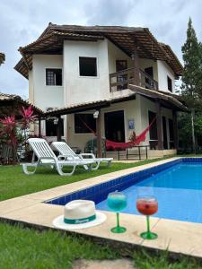 uma villa com piscina em frente a uma casa em Casa Bege - Gaia aluguel temporada Mcz em Maceió