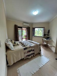 um quarto com uma cama, uma secretária e uma janela em Casa Bege - Gaia aluguel temporada Mcz em Maceió
