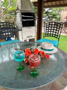 uma mesa com dois cocktails e um chapéu em Casa Bege - Gaia aluguel temporada Mcz em Maceió