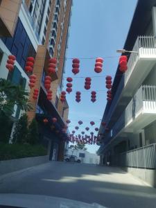 a street with red lanterns hanging between buildings at K AVENUE FAMILY ROOM B09 in Donggongon