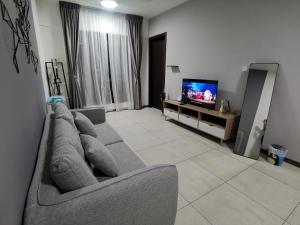 a living room with a couch and a tv at K AVENUE FAMILY ROOM B09 in Donggongon