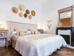 ein Schlafzimmer mit einem großen Bett mit Hüten an der Wand in der Unterkunft Gîte Bouvron, 6 pièces, 11 personnes - FR-1-306-838 in Bouvron