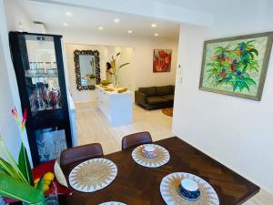 a dining room with a table and a living room at Trinity Beach Oasis in Trinity Beach