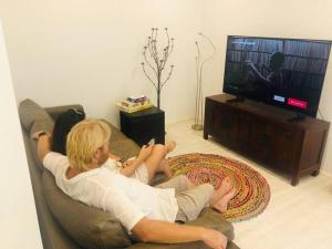 two people sitting on a couch playing a video game at Trinity Beach Oasis in Trinity Beach