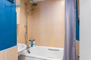 ein Badezimmer mit einer Dusche, einer Badewanne und einem Waschbecken in der Unterkunft Tranquil 2 bed apartment Edinburgh in Edinburgh