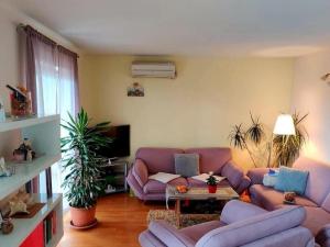 un soggiorno con divano viola e tavolo di Apartments by the sea Duce, Omis - 21876 a Omiš (Almissa)