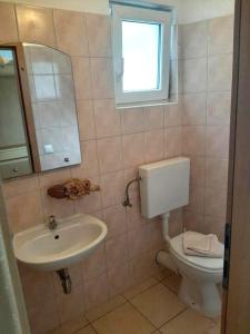 bagno con lavandino, servizi igienici e finestra di Apartments by the sea Duce, Omis - 21876 a Omiš (Almissa)