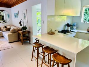 cocina y sala de estar con encimera y taburetes en Sandy Bay Haven en Sandy Bay