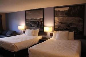 two beds in a hotel room with two lamps at Super 8 by Wyndham Kamloops On The Hill in Kamloops